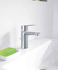 BauLoop Single Handle Bathroom Faucet With 1.5 GPM Flow Chrome Finish And Ceramic Cartridge next to green soap on sink