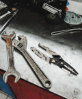 Pretyzoom 7-In-1 Cable Stripper And Crimper For Electricians on a metallic workbench with wrenches.