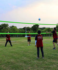 People playing with Portable Backyard Volleyball Set With Durable Net All Weather Construction Includes Pump Wrap Yarn Volleyball Boundary Lines Carry Bag Classic Blue Green Easy Setup For Instant Play