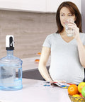 Woman using Electric 5 Gallon Water Dispenser Pump Portable USB Rechargeable For Universal 2 To 5 Gallon Bottles in kitchen