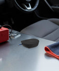 Compact 30 Gram Self Activating Aerosol Fire Extinguisher For Trucks And Cars With Automatic 170 Degree Heat Trigger sits on car console.