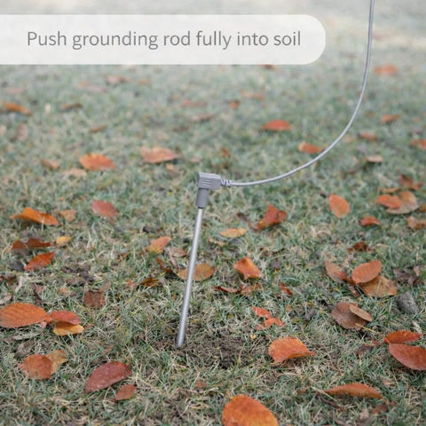 Grounding rod stake with gray 40 ft conductive cord on grassy lawn with autumn leaves