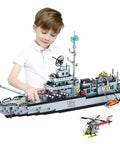 Child assembling massive 8 in 1 military battleship building set with 31.5 inch navy warship model and helicopter