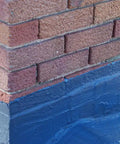 Brick chimney with brushable black elastomeric chimney flashing sealant for waterproof leak protection around chimneys, vents and skylights