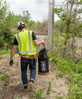 Worker carrying Beefy Heavy Duty Canvas Tool Bucket With Zip Top Flame Resistant Closure For Overhead Lifts through field