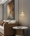 Dope Modern Crystal Pendant Light In Gold Brushed Brass Finish With 4.33 Inch K9 Crystal in a stylish living room setting