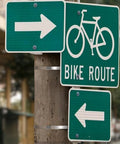 Green bike route sign and arrows on a post, secured with Center Punch Clamp Five Eighths Inch Wide 0.025 Inch Thick Five Inch Diameter 201 Stainless Steel Box Of 25 High Strength Corrosion Resistant Clamp For General Maintenance And Emergency Field Repairs.