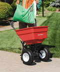 Red Pro Grade Heavy-Duty 100 Lb Broadcast Fertilizer Spreader with a 3350 cu in hopper on a lawn, showing 13 inch pneumatic tires.
