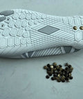 Zureto copper grounding rivets for barefoot shoes; pile of small copper rivets beside a white/gray shoe sole.
