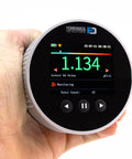 Heavy Hitter Radon Detector For Homeowners Featuring Upgraded Version 2.0, held in hand, displaying monitoring values on color LCD.