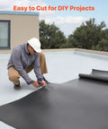 Person cutting Tough As Nails 10 X 15 Ft Roll Roofing With 45 Mil EPDM Rubber Membrane for DIY project on roof.