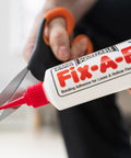 All In One Floor Repair Adhesive For Loose Hollow Tiles And Creaky Wood From A Simple Squeeze Tube With Precision Tip Drill And Fill No Mess Easy To Use For DIY And Pro Grade Installations Made In The USA Fix Floors Fast And Durable tube close-up with scissors opening spout