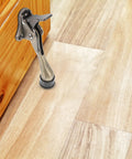 Kickdown Door Stopper For Commercial And Garage Doors Dope Heavy-Duty Zinc Alloy Build With Foot-Operated Design shown on wood floor