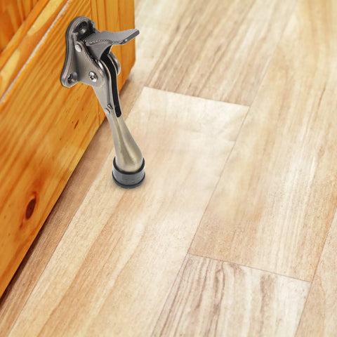 Kickdown Door Stopper For Commercial And Garage Doors Dope Heavy-Duty Zinc Alloy Build With Foot-Operated Design shown on wood floor
