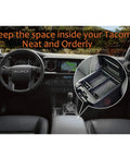 Interior view of Toyota Tacoma featuring center console with organizer tray, displaying neat storage for gear. Tray details inset.