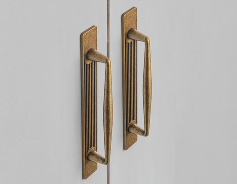 Antique Brass Zinc Alloy Cabinet Handle With Backplate 5 Inch Hole Center 128mm installed on white cabinet doors, front view