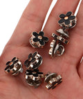 Twenty Piece Black Flower Snap Buttons Slick Metal Clip On Fasteners For Apparel Repairs displayed in hand, featuring black flower design.