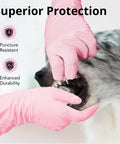 A hand wearing Top Shelf Disposable Nitrile Dish Gloves With Extended 12 Inch Cuff, 6 Mil Thick Guard, Cherry Blossom Print, Latex Free, Straight Up Reliable For Deep Cleaning And Hair Dye, Box Of 100, examining a dog's mouth.
