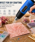 Powerful 900W Heat Gun with Dual Temperature Settings used on pink embossing project surrounded by crafting materials