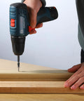 Person using a drill to drive a wood screw set no 8 x 1 inch phillips modified truss head self tapping stainless steel 410 into wood