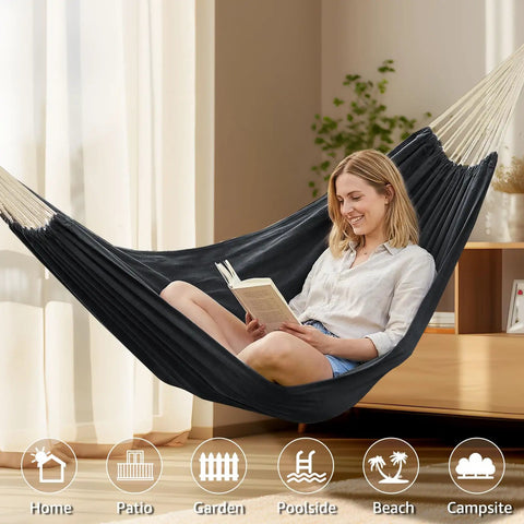 Woman reading in a Cotton Portable Camping Hammock With Tree Straps Up To 660 Lbs Travel Bag Indoor Outdoor Patio Backyard Comfort Fabric Hammock For Relaxation All Season Lounging Anywhere