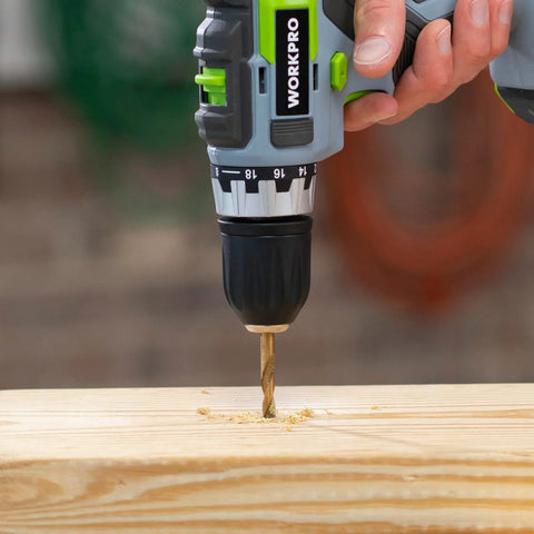 WORKPRO cordless drill with twist drill bit drilling into wood; close-up view showing brand on the drill.