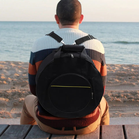 Road Ready Snare Drum Case And Gig Bag With Badass Thickened Padding And Adjustable Shoulder Strap For Smooth Hauling Of Your 14 Or 15 Inch Snare In Sleek Matte Black on beach.