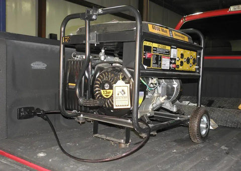 Portable 6000 watt generator on truck bed showing control panel and wheels for easy transport, suitable for outdoor power needs.