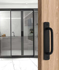 Front view of Black Barn Door Handle Set 2 Pack With 128mm Hole Center Sliding Cabinet Pulls, 5.83 Inch Length installed on a wooden door.