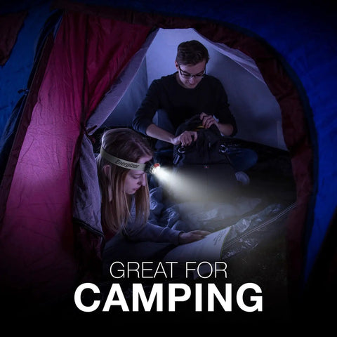 Vision HD Plus LED Headlamp with pivoting beam used inside a tent, illuminating two campers, hands-free for camping use.