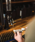 Person using Bench Top Powder Measure With Improved Funnel Shape And Static Free Aluminum Body For Accurate Ammunition Reloading Micrometer Adjustable Charge From 10 To 100 Grains Black at reloading bench.