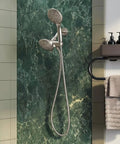 Brushed nickel Dual Shower Head Combo 2-in-1 Water Saving System with 59-Inch Stainless Steel Hose, mounted on green marble wall.
