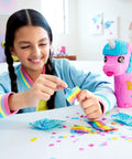 Child opening surprise accessory from Unicorn Partyland Playset With Pocket Dolls And Pets, 25 Plus Surprise Accessories, Birthday Celebration Adventure With Hot Air Balloon Ride, Two Micro Dolls Included, Rainbow Themed Fun For Kids package.