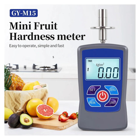 Digital Fruit Hardness Tester Handheld Sclerometer Penetrometer with clear display on a kitchen counter beside fresh fruits.