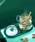 Smart Cup Warmer Heating Pad With Adjustable Temperature Controls Keeps Your Morning Drip Piping Hot All Day features a glass cup with herbs.