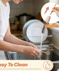 A person rinsing the Handheld Electric Baby Formula Mixer With 2 Stirring Sticks under a faucet, demonstrating easy cleaning.