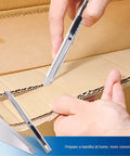 Close-up of EHDIS vinyl wrap tool kit, 7 pieces; silver cutting knife with blades against a cardboard box backdrop