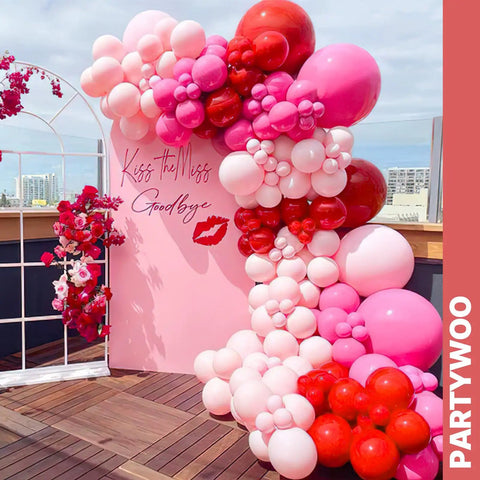 Balloon arch made of 66 Piece 12 Inch Hot Pink And Red Balloons Set With White And Gold Confetti for party decor on a rooftop.