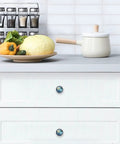 Top Shelf 4 Pack Of 1.37 Inch Round Cabinet Knobs Serving A Sharp Blue Marble Pattern Durable Glass Composite Includes Heavy Duty Stainless Steel Screws A Major Game Changer For Quick Kitchen Cupboard Drawer Home Refresh Projects on white drawer with vegetables.
