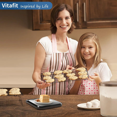 Mother and daughter with cookies, next to 22 Pound Digital Kitchen Scale With 0.1 Ounce And 1 Gram Precision For Cooking And Baking, pro grade.