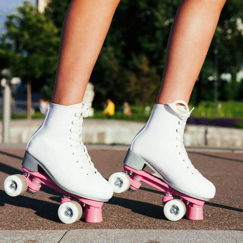 Woman skating outdoors wearing white boots with 32 x 58mm PU Roller Skate Wheels With Bearings, 4 Pack Quad Replacement, 82A hardness.