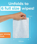Hand holding a 7x5.5 inch wipe, from Ultra Compact Travel Flushable Wipes With 99.5 Percent Water And Aloe, showing size and thickness.