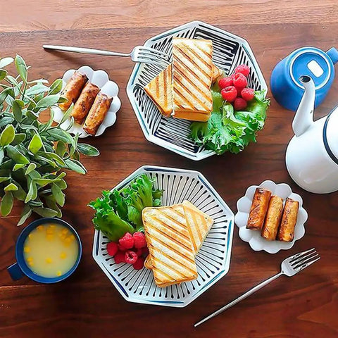 Two plates with grilled sandwiches, raspberries, lettuce, and snacks, showcasing Durable Aluminum Grilled Sandwich Maker For Stovetop Use.