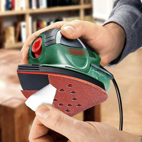 Person applying 12-hole sanding pad to detail sander, highlighting No Fuss Mouse Sander Sanding Pads Set, 50 Pack With 60 80 120 150 And 220 Grits.