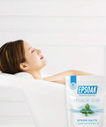 Muscle Recovery Epsom Salt Soak With Eucalyptus And Peppermint Essential Oils, 12 Lbs Total bag beside a relaxing bath scene