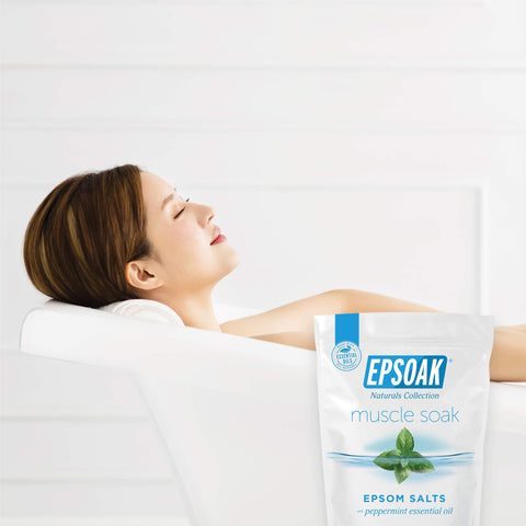 Muscle Recovery Epsom Salt Soak With Eucalyptus And Peppermint Essential Oils, 12 Lbs Total bag beside a relaxing bath scene