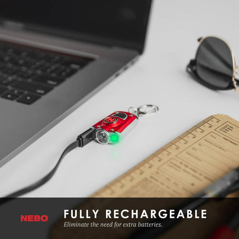 Mycro Keychain Flashlight 400 Lumen Rechargeable EDC Light connected to laptop via USB for charging next to notebook and sunglasses.