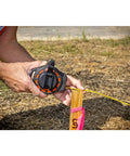 Worker using Three Eighths Inch By Fifty Foot Steel Construction Long Tape Measure With Three To One Gear outdoors.