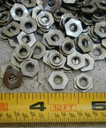 Rock Solid Eight Thirty Two Clinch Nut Pack Of Fifty Corrosion Resistant Stainless Steel hardware with smooth threading on a ruler.