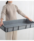 Movable Mop And Broom Holder In Stainless Steel With Drainage Basin being held, showing front view